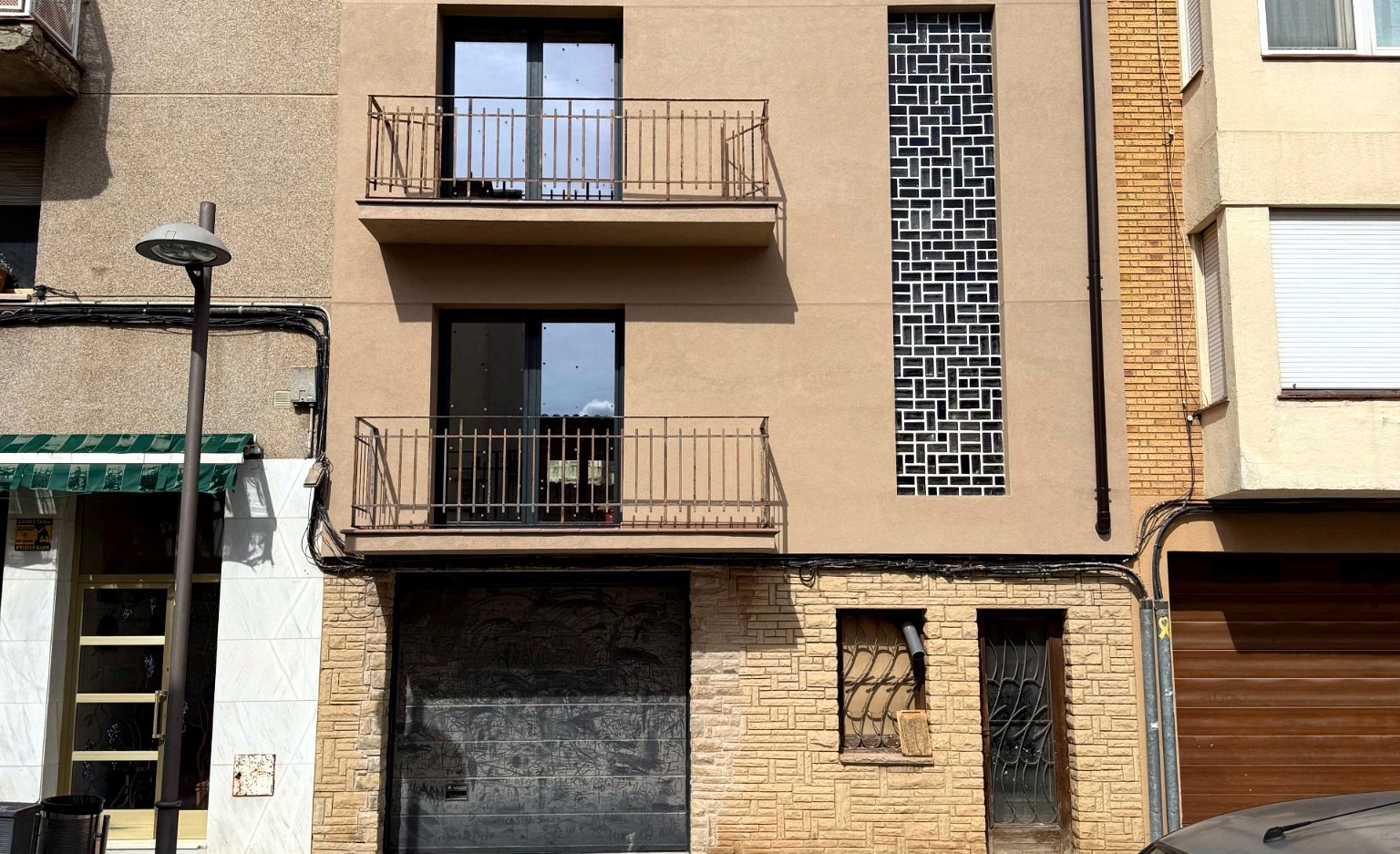 Fachada entre medianeras con el acabado renovado